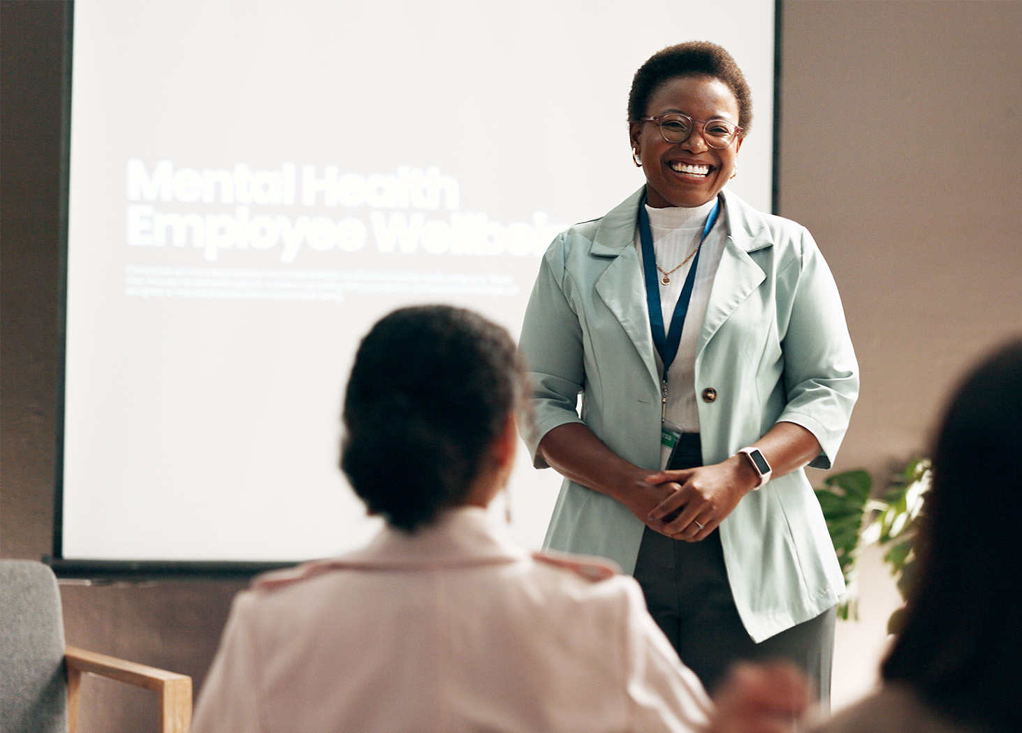 Speaker presenting employee wellbeing benefits to a small group